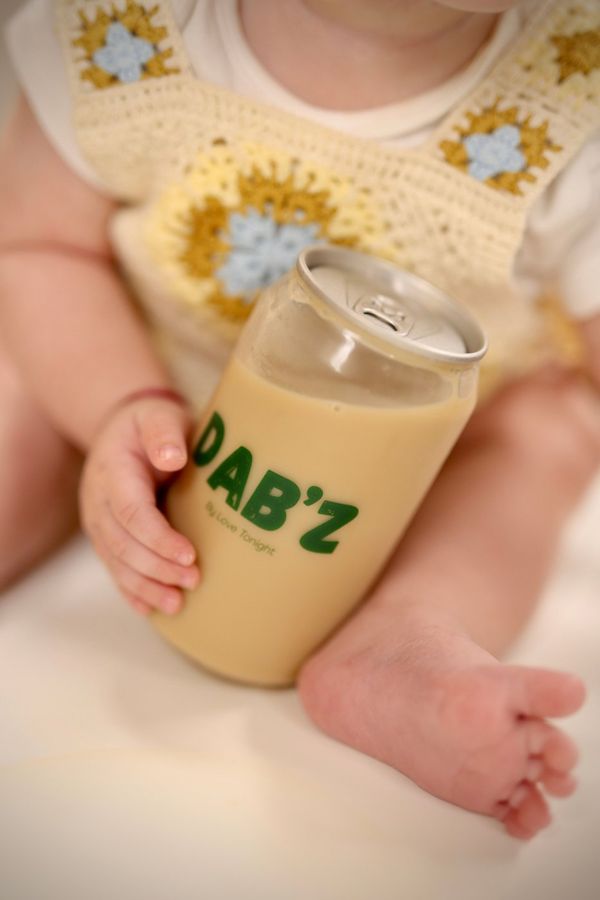Un bébé tient une canette Dab'z de café au lait glacé