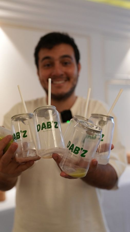 Un barista présente trois canettes Dab'z
